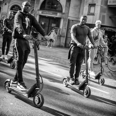 'Four Black Lives Matter Protesters on Scooters Travelling through the streets of London, London Black and White Street Photography' 