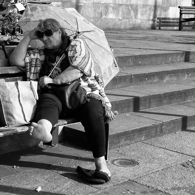 'Woman sitting on a park bench holding a umbrella,Black & White London Street Photography'