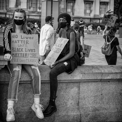 'Two young Black Lives Matter Protesters,Sitting in Trafalgar Square Holding Placards, London Black and White London Street Photography'
