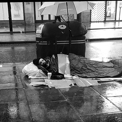 Rough sleeper  trying to keep dry London black-and-white photography