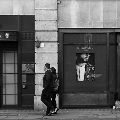 Man laying outside building London black-and-white photography