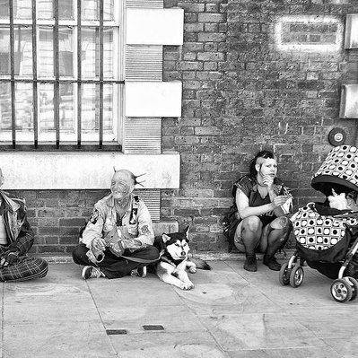 'A group of punk rockers sitting on the pavement' black-and-white photography, London