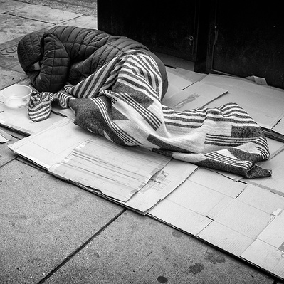 Rough sleeper sleeping on cardboard London black-and-white for photography