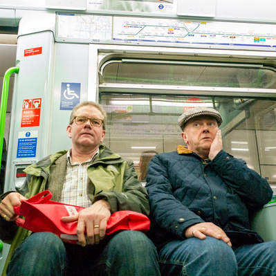 'Two man sitting on a tube train looking bored, London Street Photography Colour'