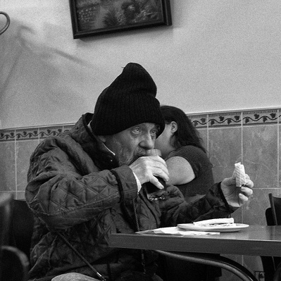 Man having a drink in a café East London black-and-white photography