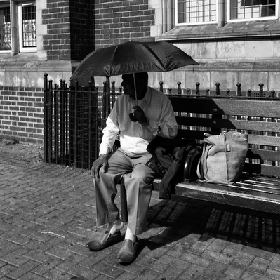 Man using umbrella, keep in the shade Tooting London black-and-white photography