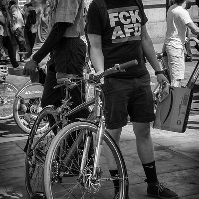 'Man on a Bicycle watches on as the Black Lives Matter protesters Walk by, London Black and White Street Photography'