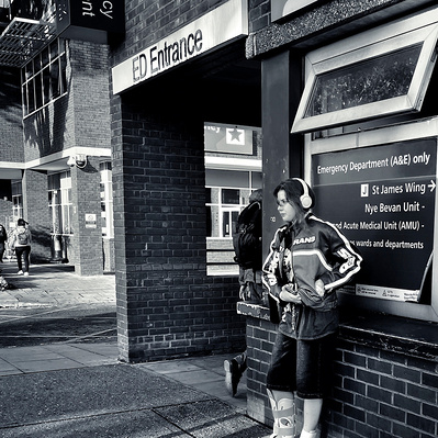 Young lady waiting outside A&E department, St George's Hospital, South London black-and-white photography
