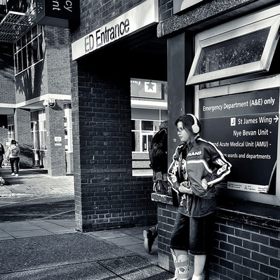 Young lady waiting outside A&E department, St George's Hospital, South London black-and-white photography