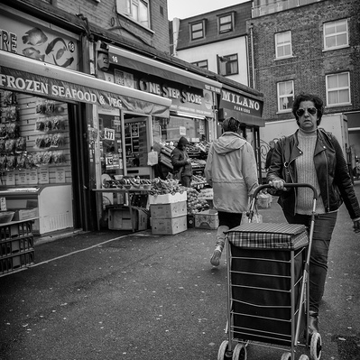 Woman pushing her shopping trolley, South London black-and-white photography