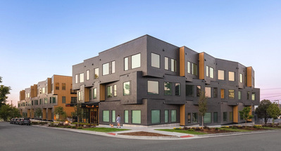 Exterior of a modern multifamily building at sunset. With a girl walking her dog.