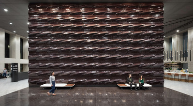 Grand lobby of Republic Plaza in Denver, featuring a spacious, modern design with sleek architectural elements and a massive terracotta wall that serves as a striking focal point.