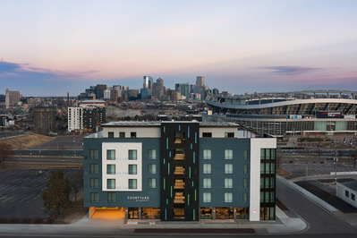 Aerial view at dusk of the Courtyard Marriott Denver Stadium, showcasing a stunning view of the stadium and Denver cityscape, highlighting the hotel's prime location and urban surroundings.