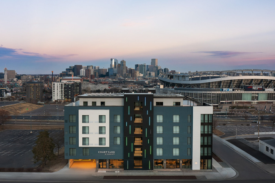 Aerial view at dusk of the Courtyard Marriott Denver Stadium, showcasing a stunning view of the stadium and Denver cityscape, highlighting the hotel's prime location and urban surroundings.