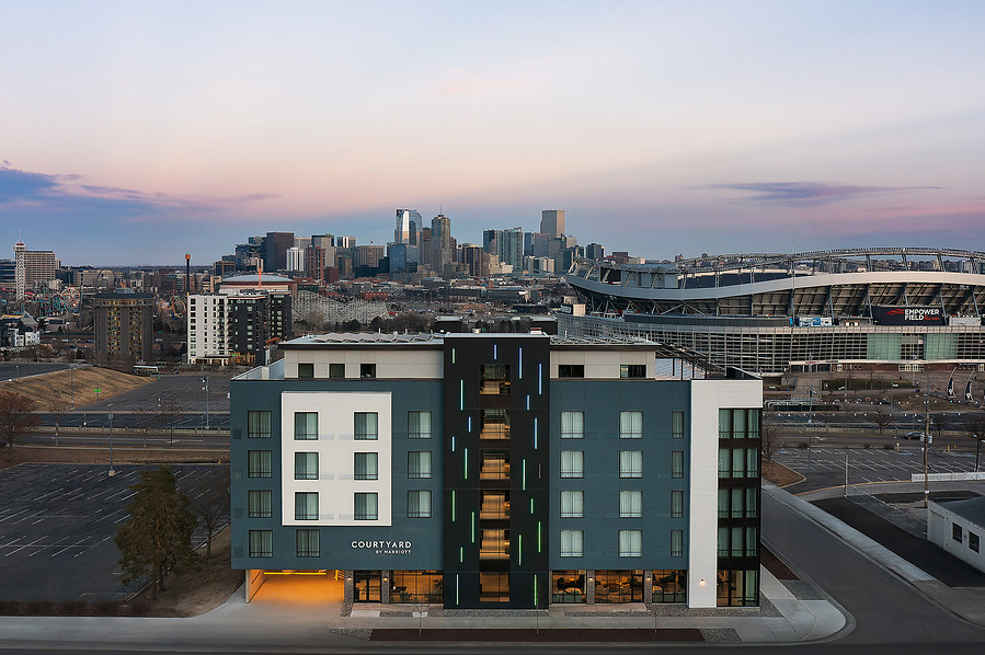 Aerial view at dusk of the Courtyard Marriott Denver Stadium, showcasing a stunning view of the stadium and Denver cityscape, highlighting the hotel's prime location and urban surroundings.