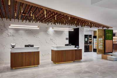 The Courtyard Marriott Denver’s stadium-facing lobby, featuring modern design elements, guest check-in, and a welcoming atmosphere that highlights the hotel's vibrant location.