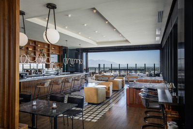 High rise bar lounge at Le Meridien Salt Lake City, featuring stylish decor and an inviting atmosphere with mountain views.