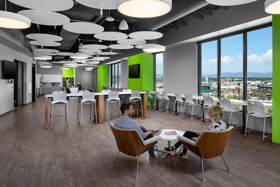 A modern workplace breakroom in Denver, featuring panoramic mountain views, sleek finishes, natural light, and a comfortable, stylish atmosphere designed for employee relaxation and collaboration.