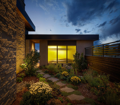 A courtyard with a garage and the silhouette of a sports car at twilight.
