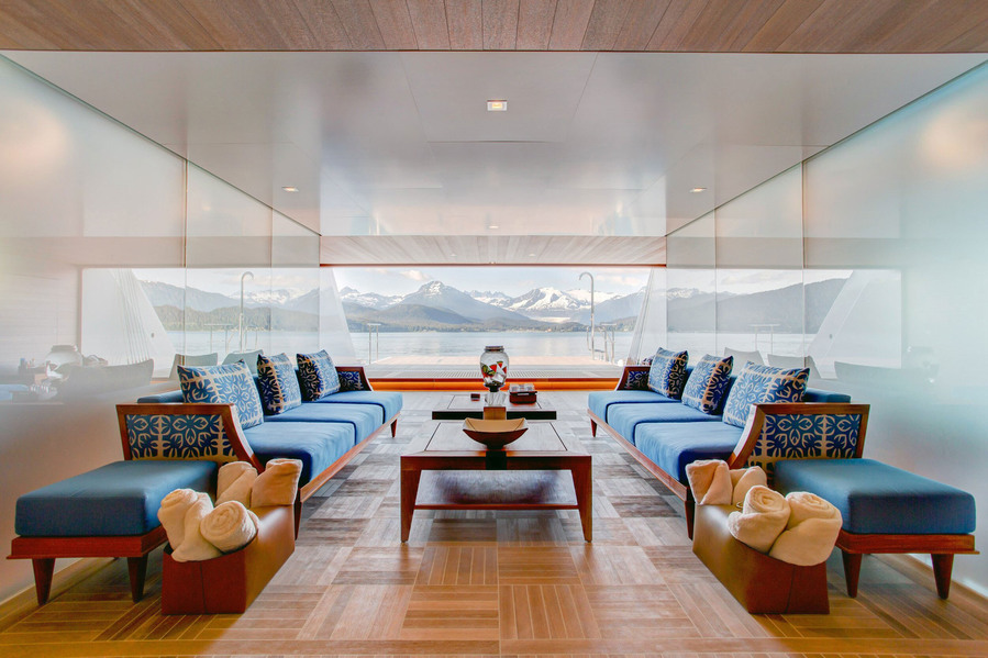 Interior photograph of the beach deck on a luxury mega yacht in Alaska, showcasing sleek finishes and open access to the surrounding seascape.