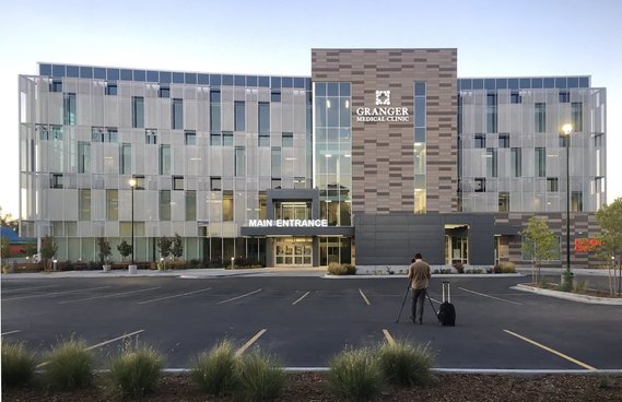 Tim Gormley at his camera and tripod capturing a exterior twilight image of a healthcare medical building for HKS Architects.
