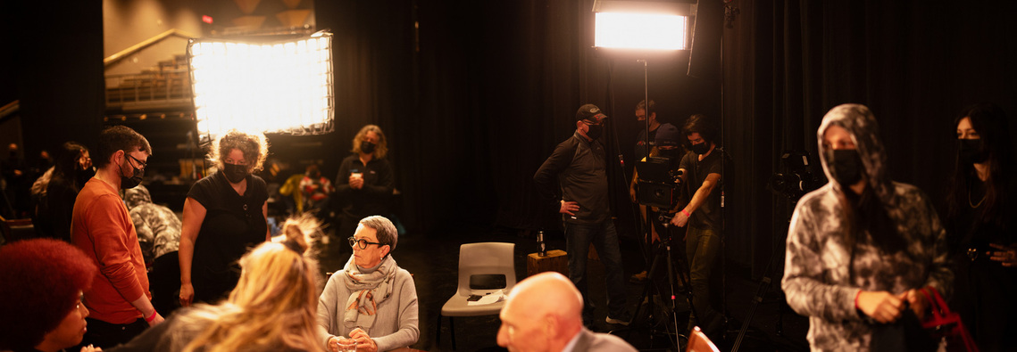 Panoramic shot of cinematographer Gerry Kingsley on set with director B.P. Paquette, cast and crew blocking a scene for the feature film 