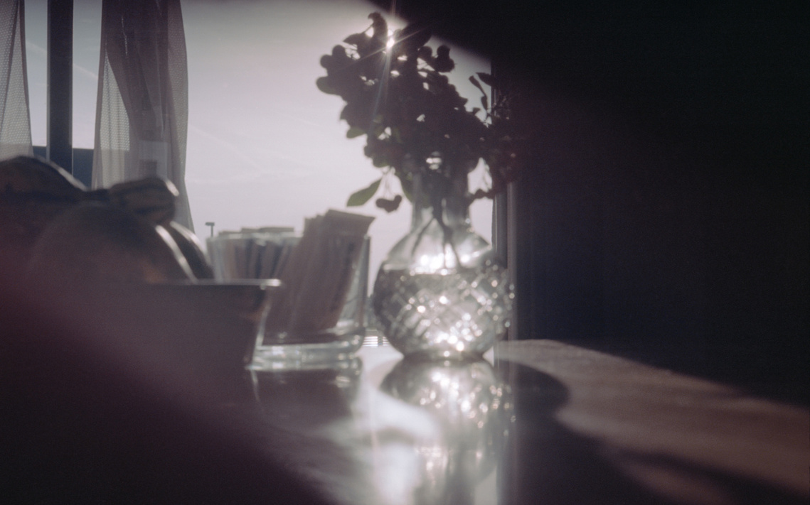 Morning light streaming across a café table, captured on analog film, evoking quiet reflections and the serene beauty of simple daily rituals.
