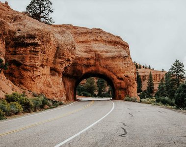Paved road leading to a natural rock tunnel in Bryce Canyon National Park