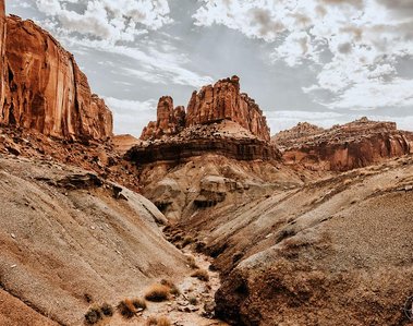 View of a canyon from the bottom of a dried river bed.