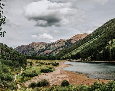 Mountain range and lake view from the forest trees.