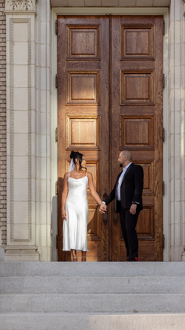 a dramatic sunset photo of a bride and groom in front of a historic building. The light highlights the bride. Atlanta, GA photography. Color wedding photos.