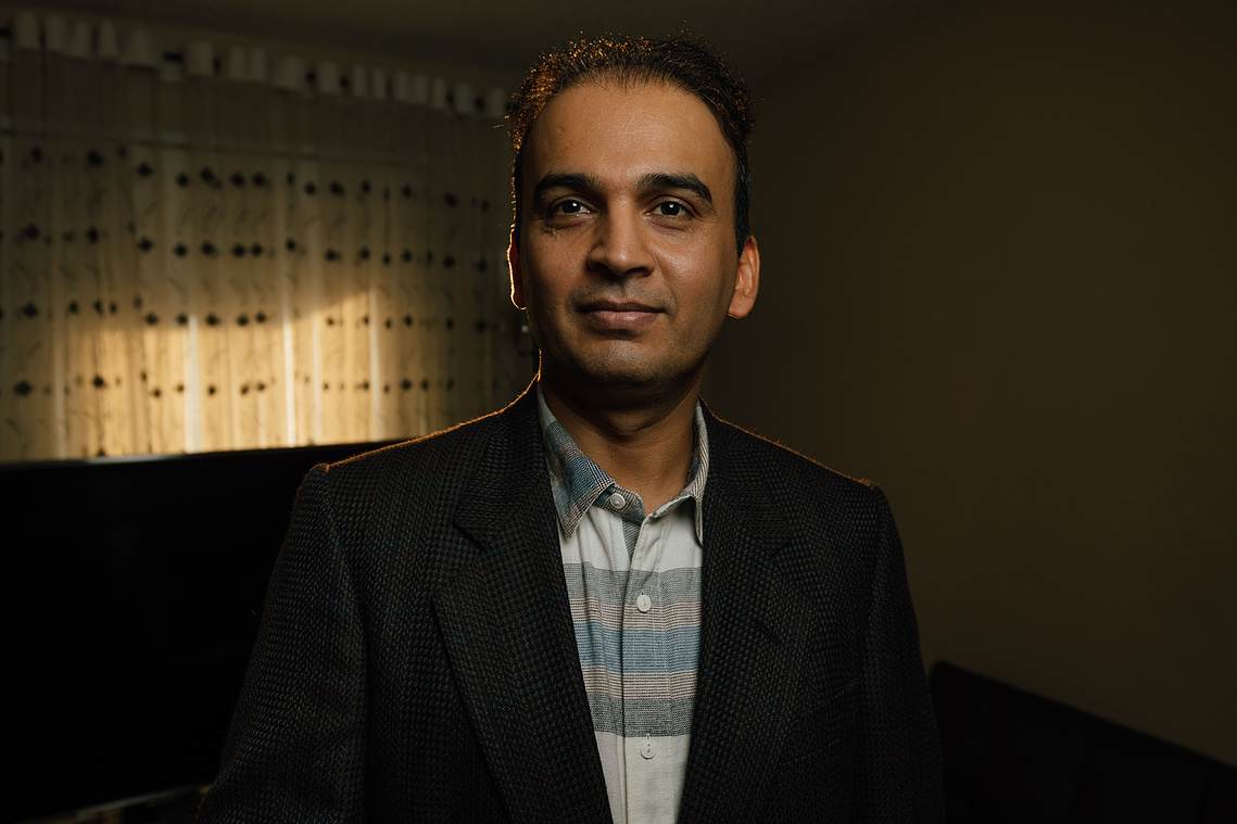 (Above Image): Rameen Aziz, age 39, gives a gentle smile as we carry a conversation in their living room about all-things-life -- stock trades, photography, kids, and coffee.