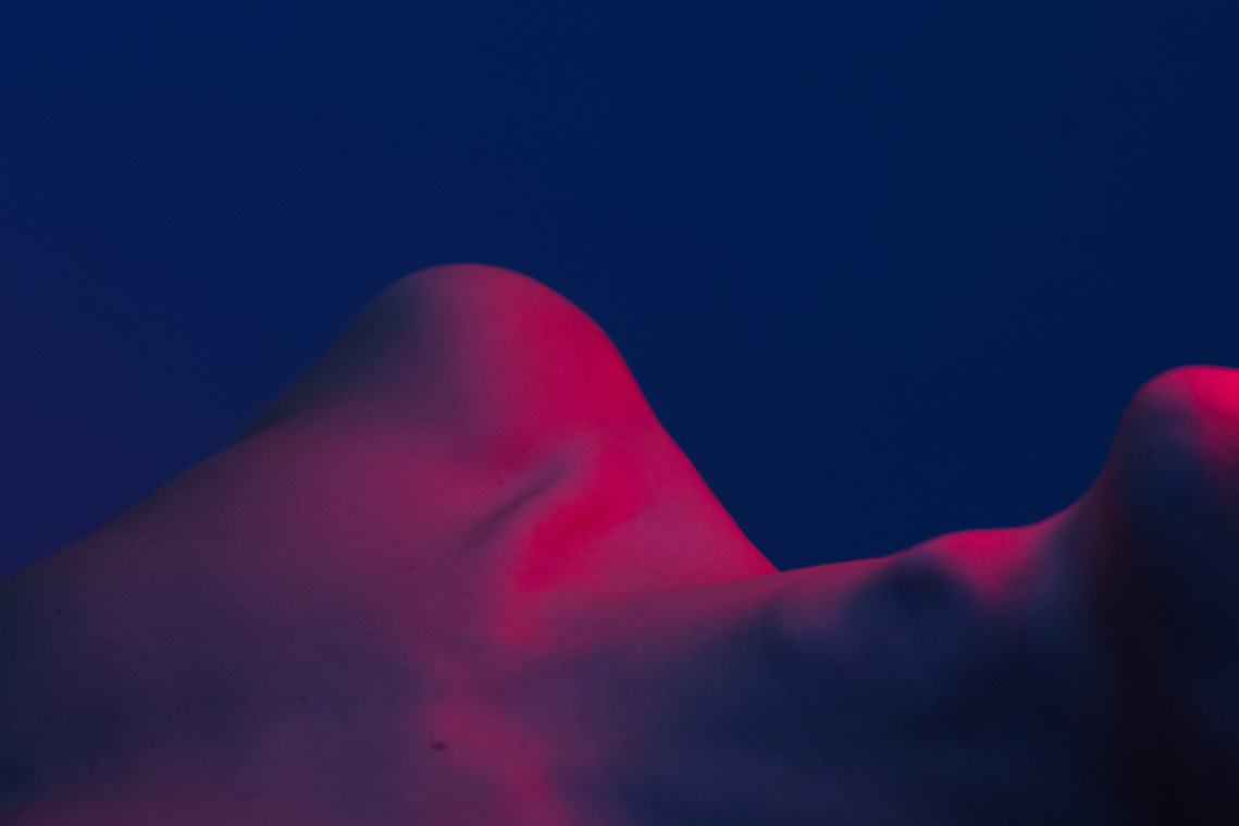 body of man in nude under purple light and it resembles the landscape of the nature 