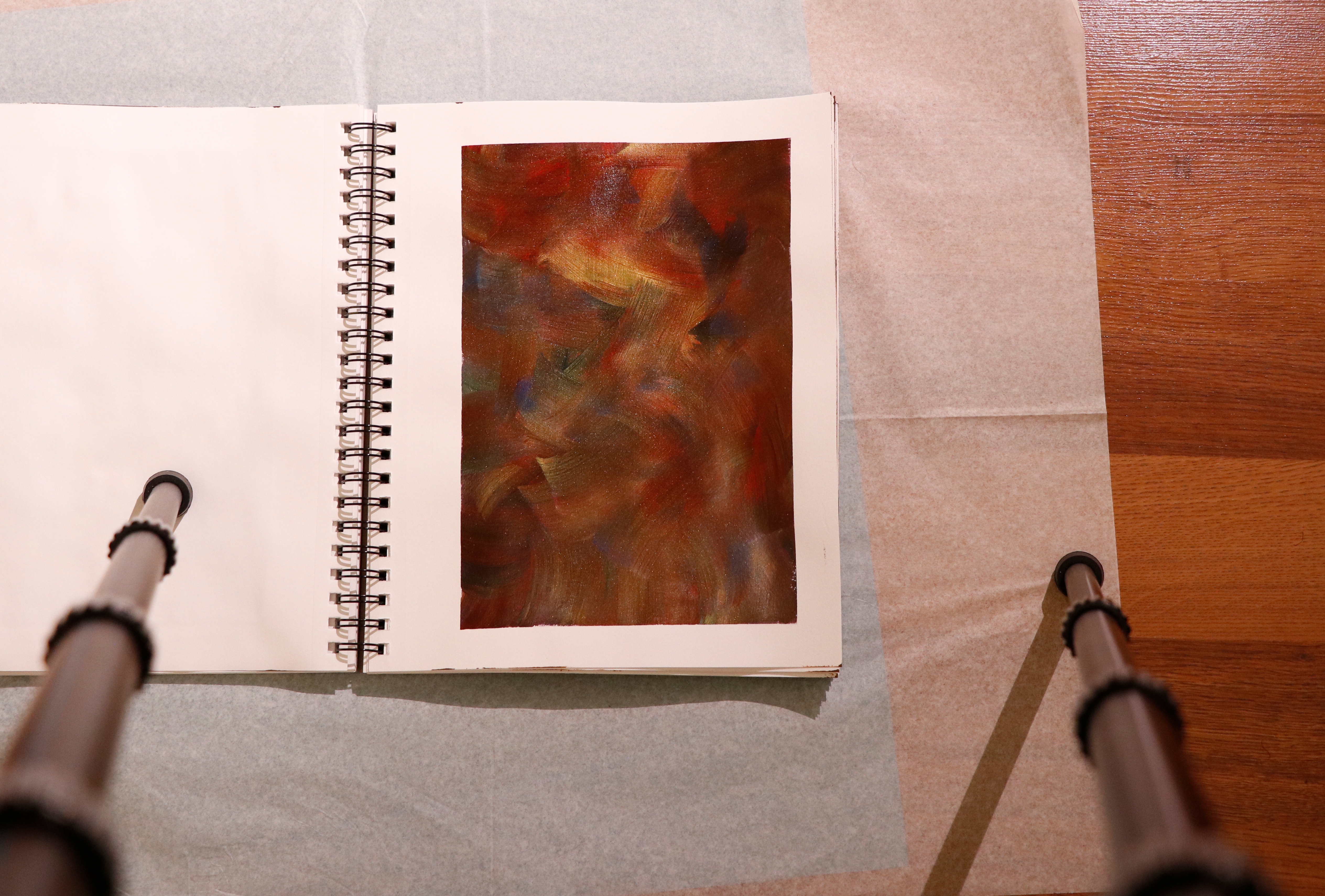 A painting in the centre with a tripod setup on both the sides.