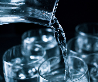 A jet of clean drinking cold refreshing spring water pouring in a glass 