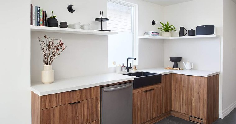 Modern galley kitchen with walnut cabinetry and open shelving. Design by Melanie Kushner Interiors