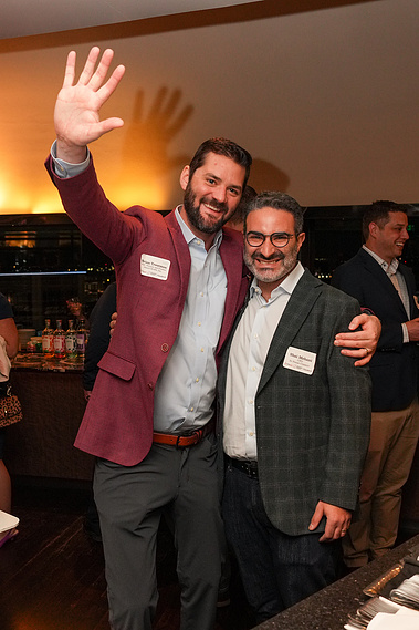 Two attendees with name badges sharing a candid moment at a corporate networking mixer