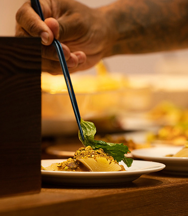 Chef plating a fine-dining dish at a corporate culinary tasting event