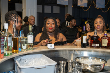 Guests gathered at the bar during a formal fundraiser reception
