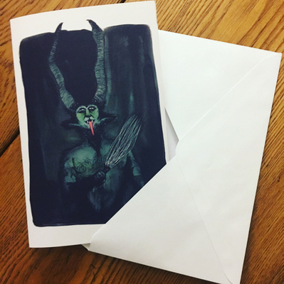 A Krampus greeting card is partially coming out of an envelope.