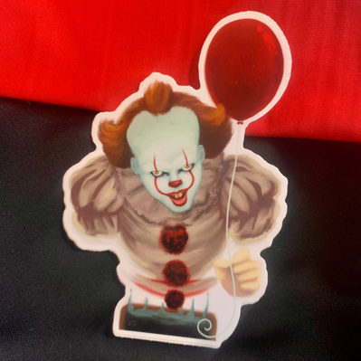 Pennywise floats above a sewer grate holding a red balloon.