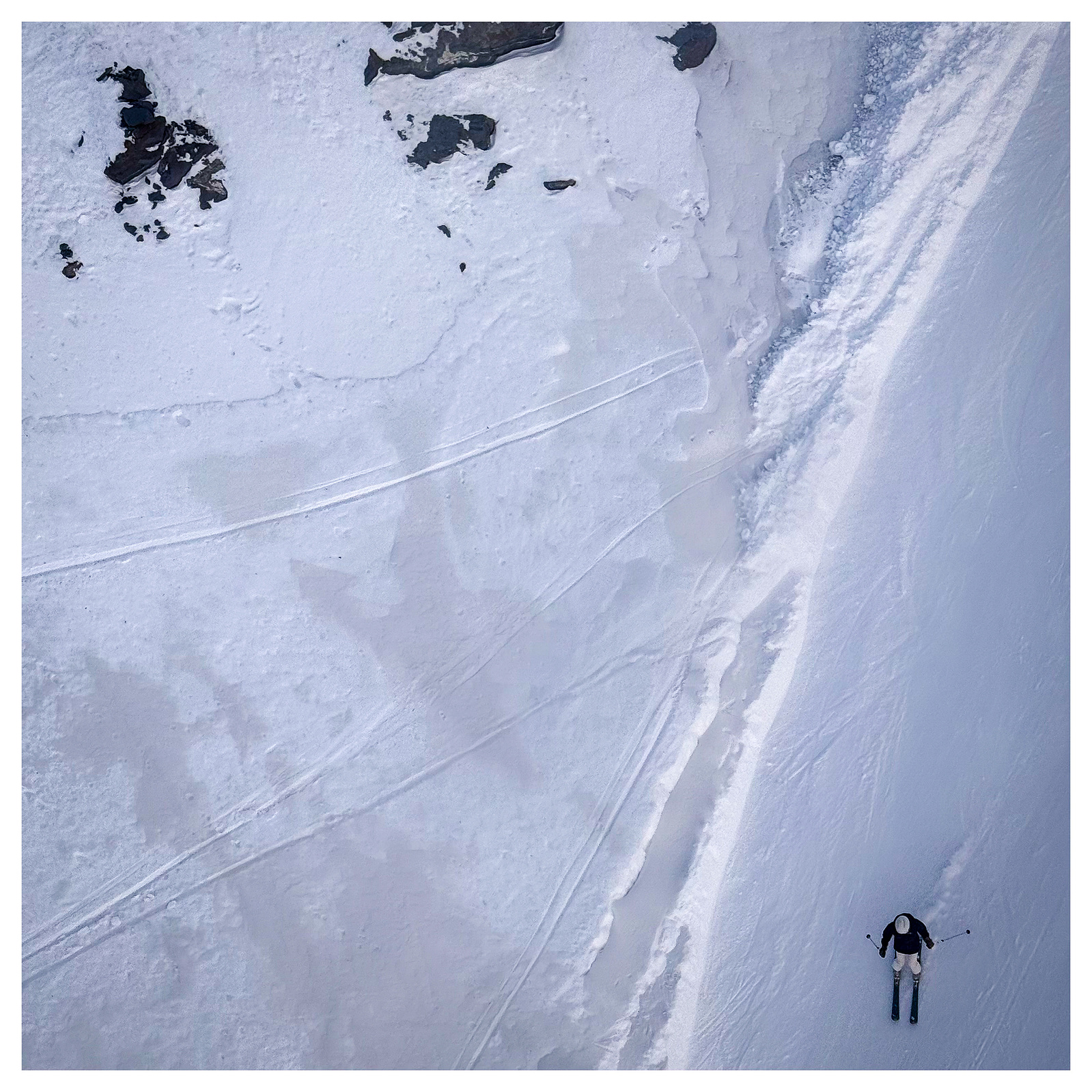 Taken from above the skier appears miniscule against the vast mountains