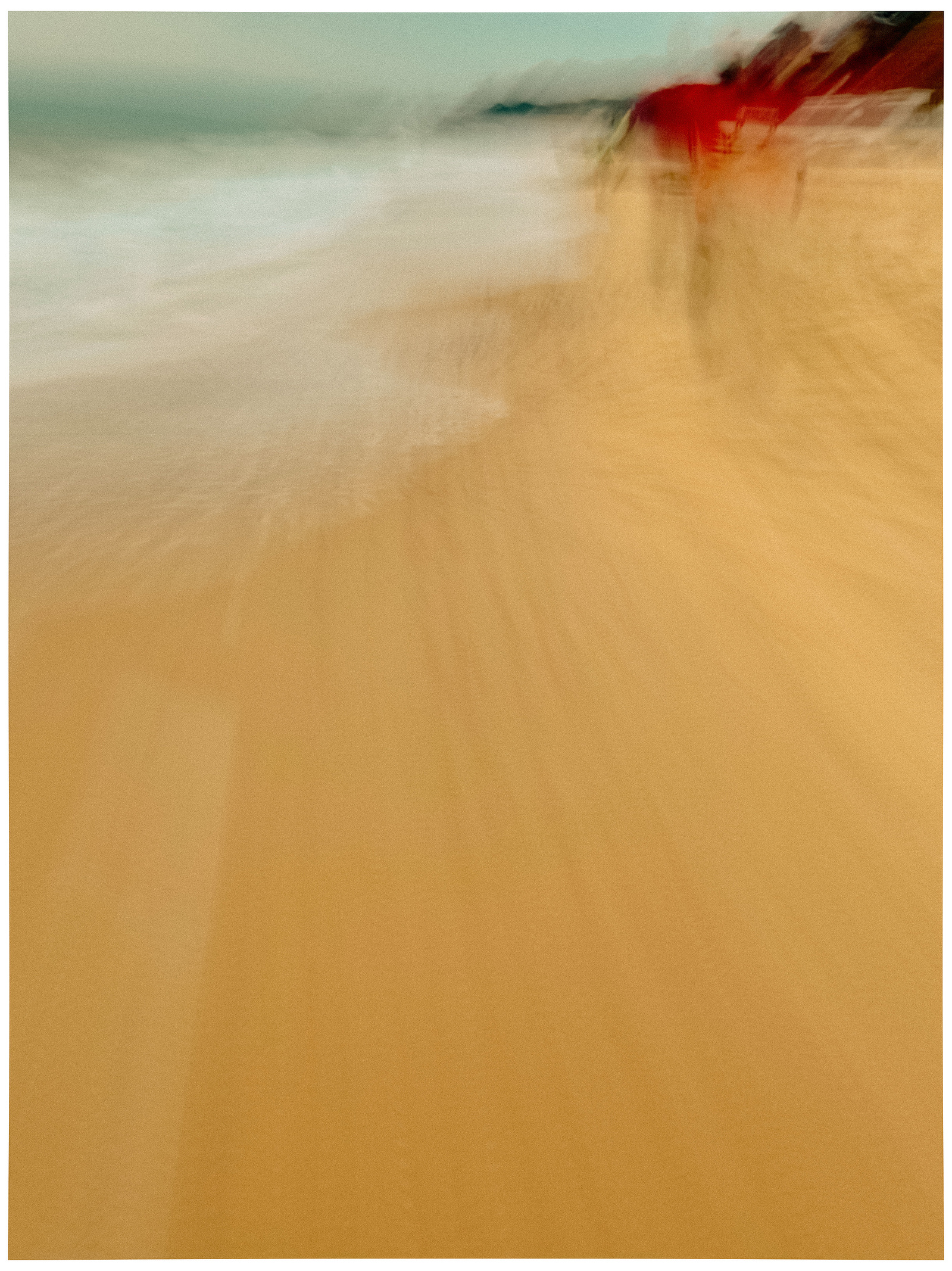 A blurred image of a person walking along the coast line