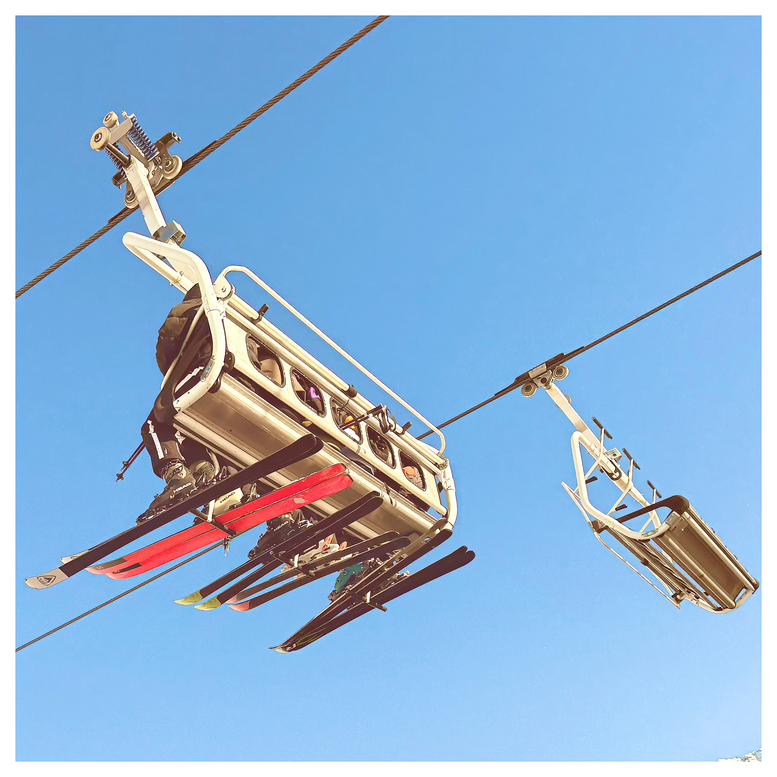 Two ski lifts pass each other in the sky