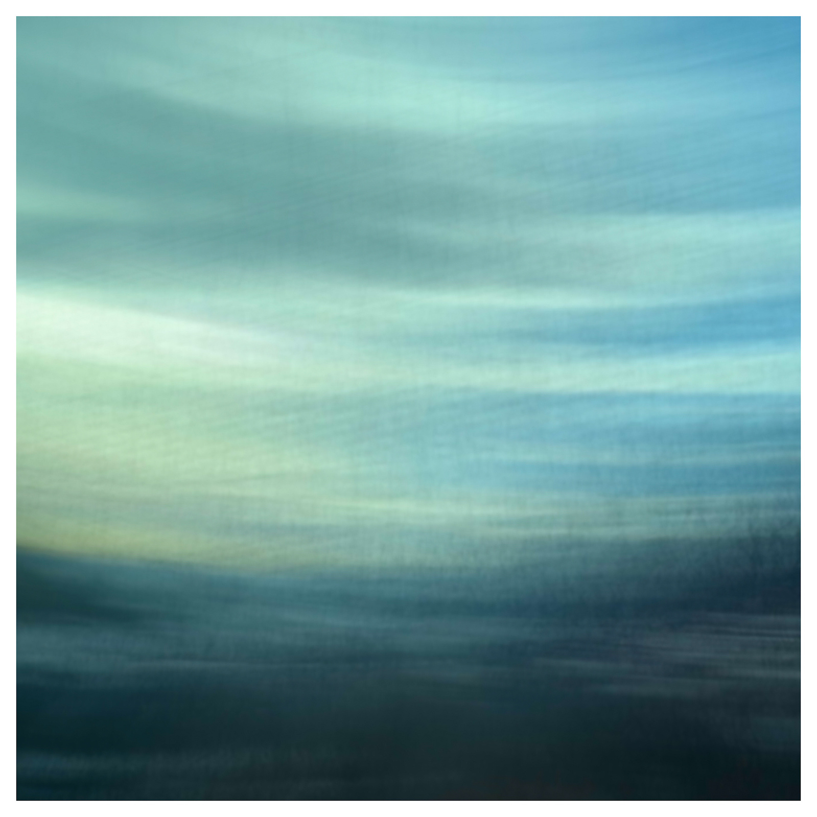 Trees, mountains, sky are all blurred blue and green as the scenery races by from inside the taxi home