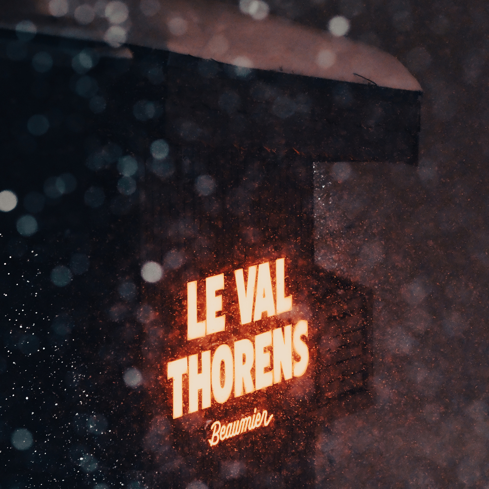 Sun falls lightly in front of a lit up sign - "Le Val Thorens"
