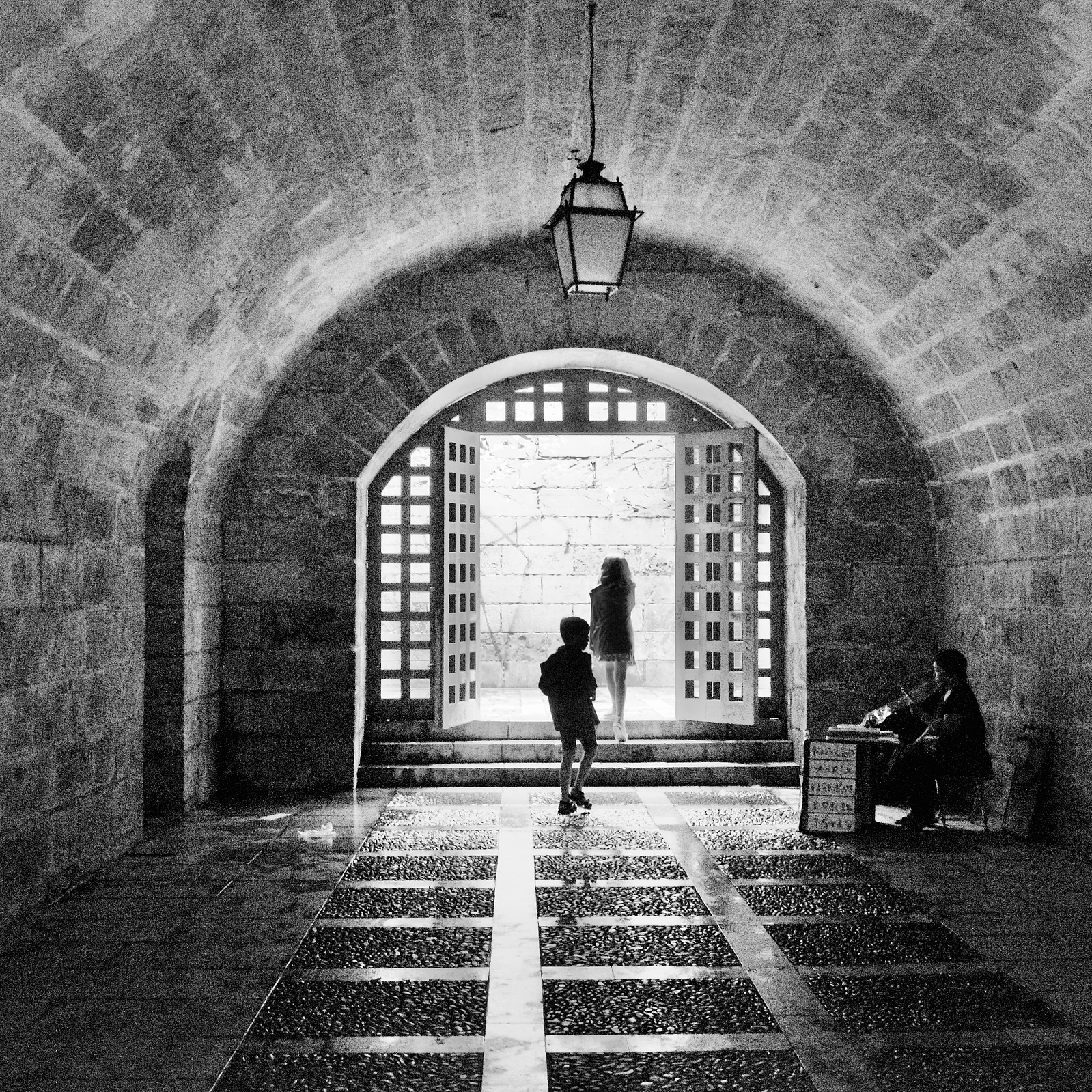 A young boy and a girl walk through a tunnel towards the light - a person is sitting at a desk. The young looks on intrigued.....