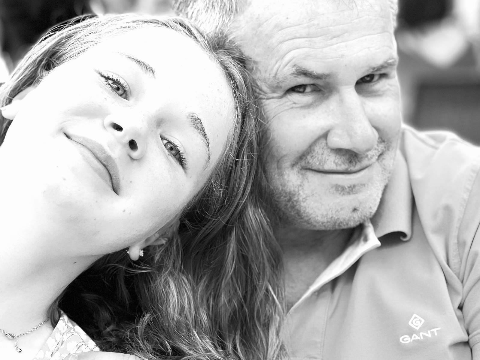 A dad and his daughter stare lovingly at the camera