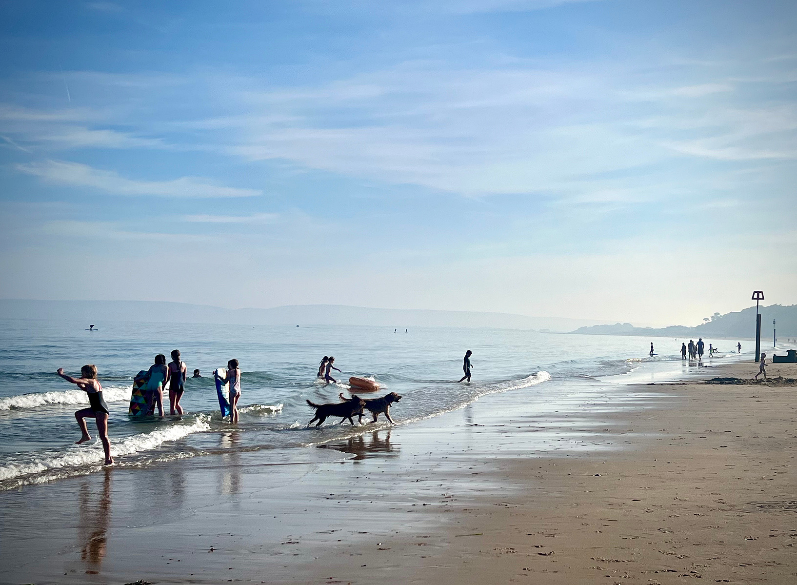 A classic beach photo of a group of children playing at the shoreline of the beach
