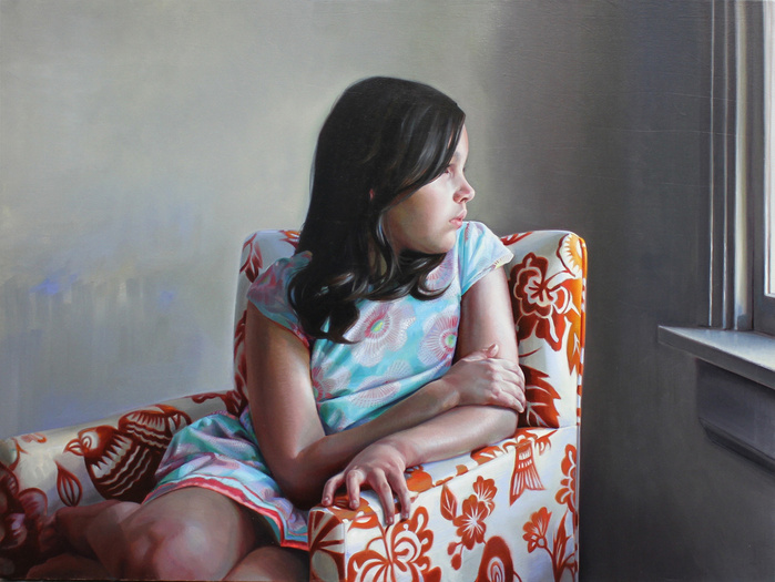 girl looking outside sitting in an upholstered chair